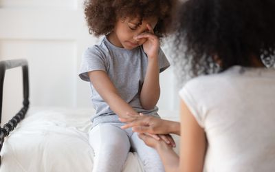 Mixed race mommy comforting upset little cute girl.