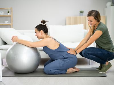 Doula supports pregnant person with prenatal massage