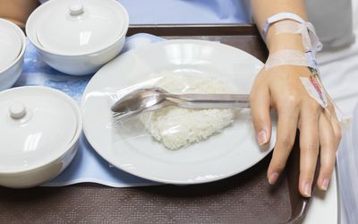 孕妇在白色的碗里滴注生理盐水和煮好的米饭和其他食物。