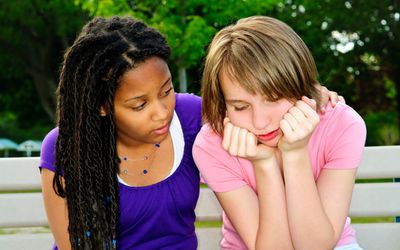 young girl comforting another