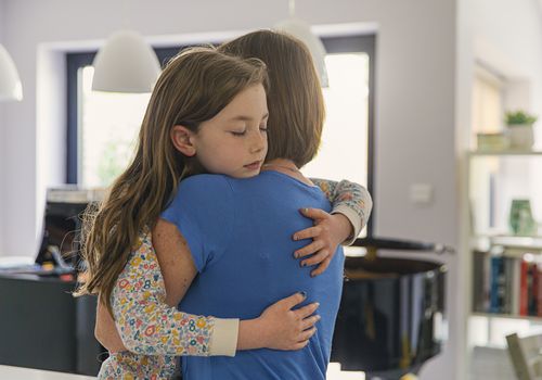 Young girl getting a big cuddle from her mum