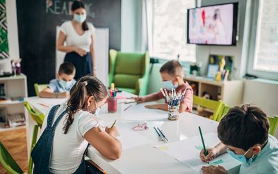 kids wearing masks while drawing