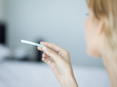 Woman looking at an ovulation test strip