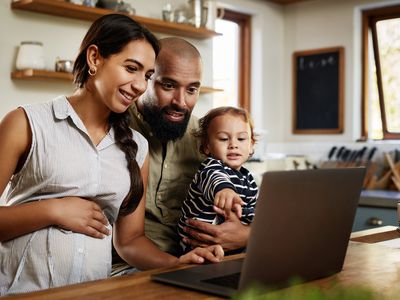 Pregnant woman with husband and child looking at the computer.