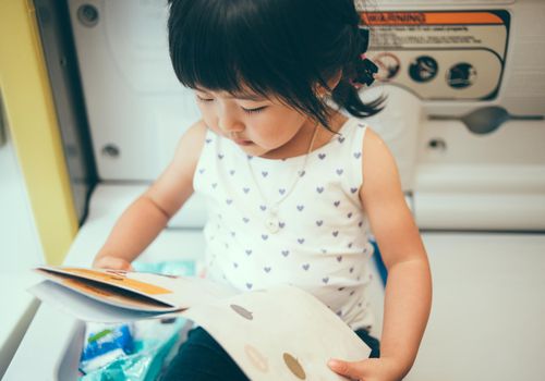 Toddler girl reading story book