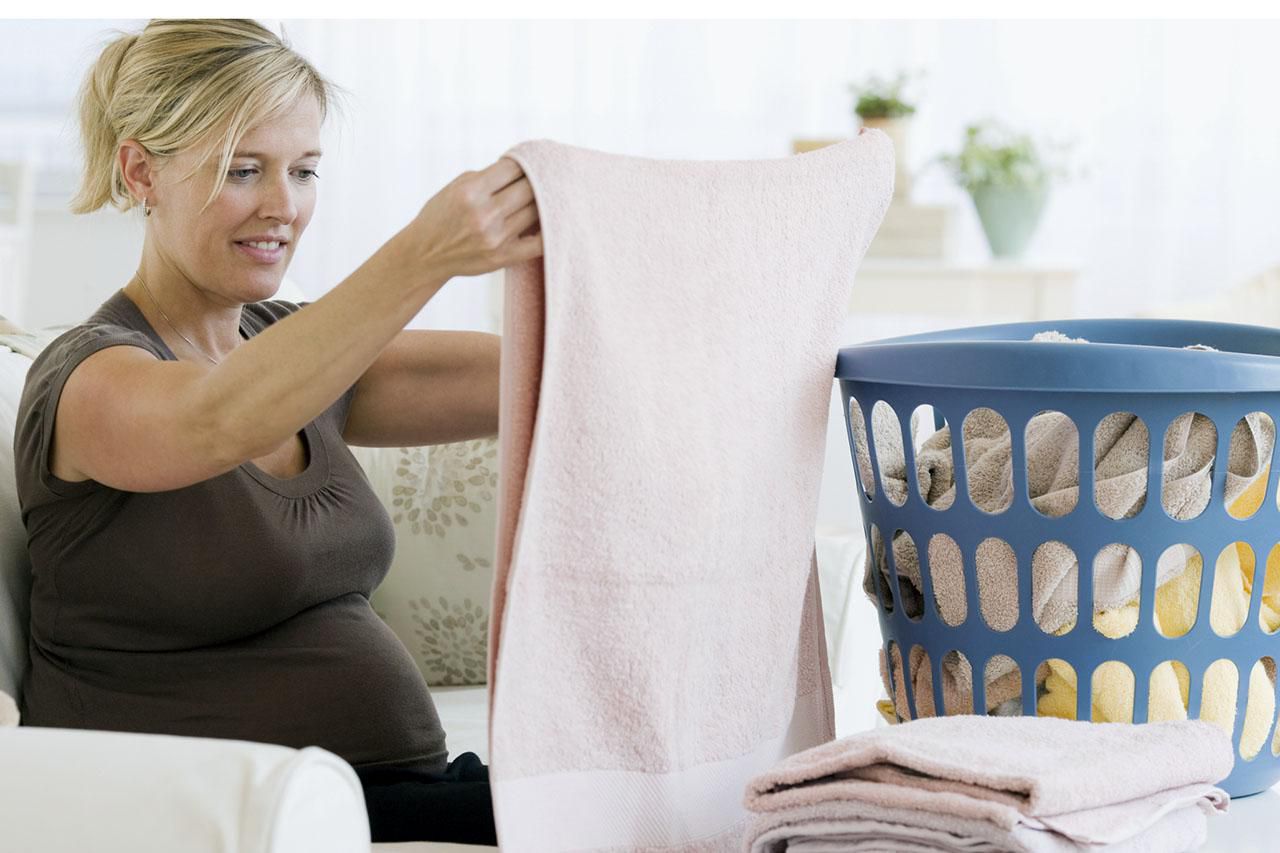 Pregnant woman folding laundry