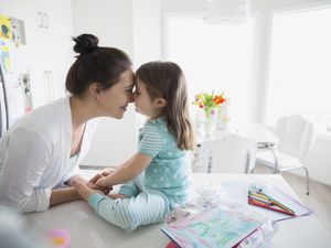 Affectionate mother and daughter rubbing noses in pajamas