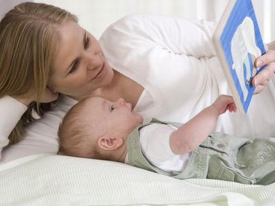 Young mother reading to her infant.