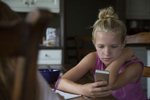 一个十几岁的小女孩在看她的手机。