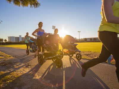 Mothers jogging in park with pushchairs