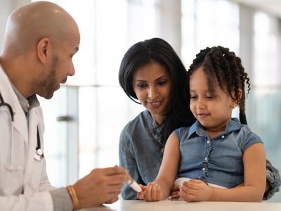 young girl and her mother talking to a pediatrician