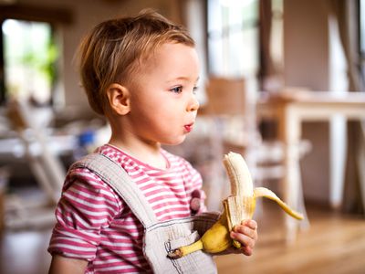 little girl eating a banana