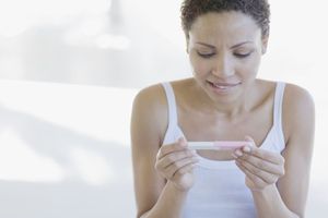 Woman looking at a pregnancy test stick