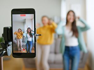 年轻女子和她的朋友用智能手机摄像头创建舞蹈视频