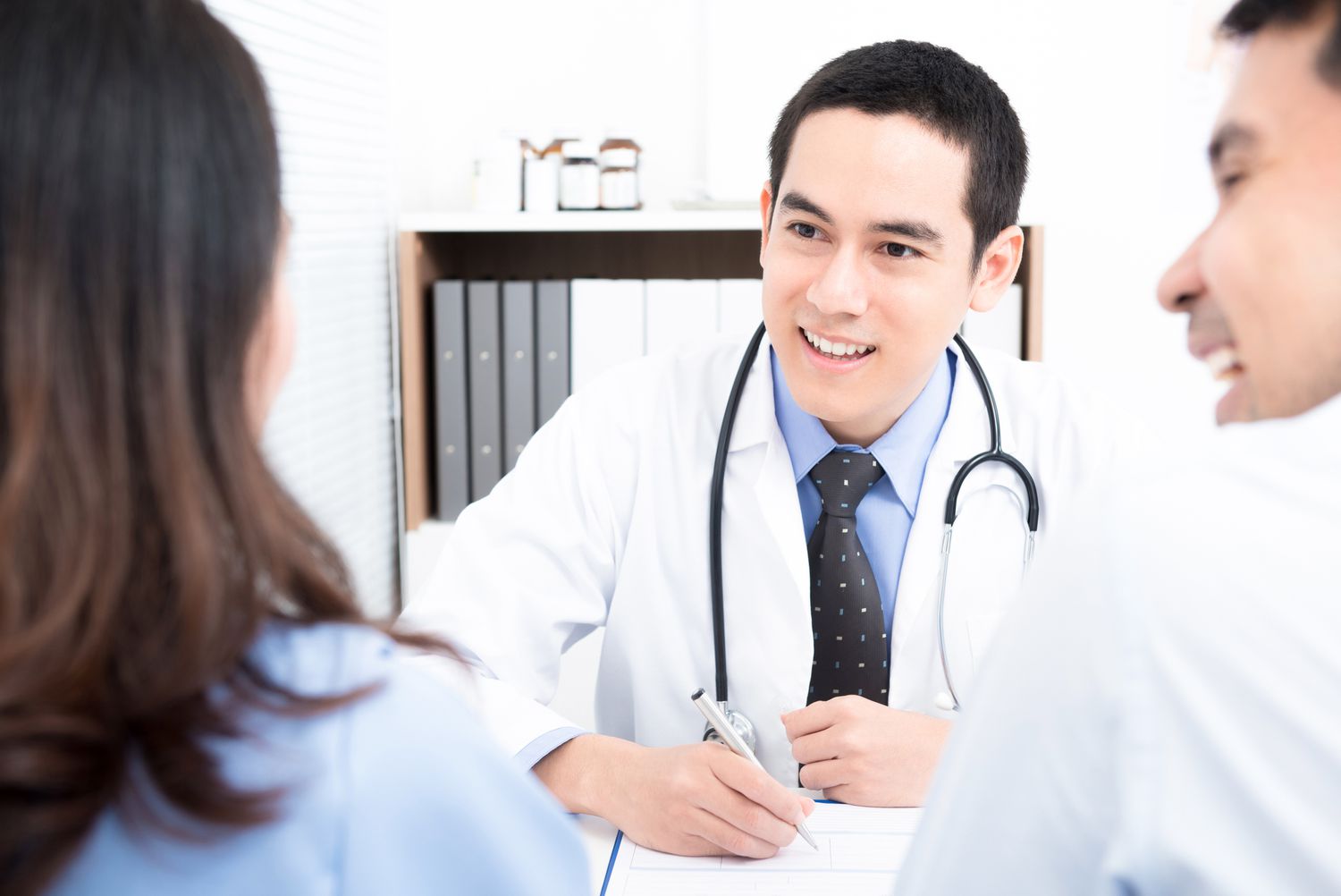 man and woman talking with doctor