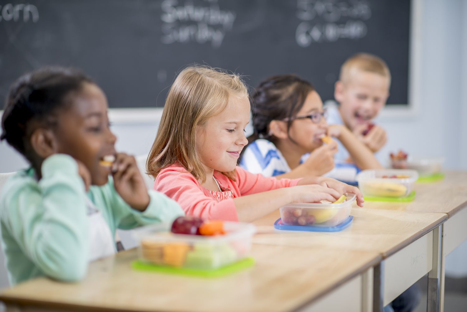 小学生们正坐在课桌前吃着健康的零食