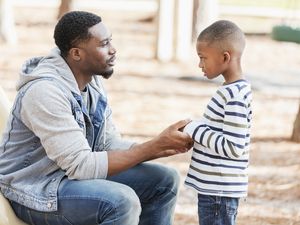 Father talking to little boy on playground