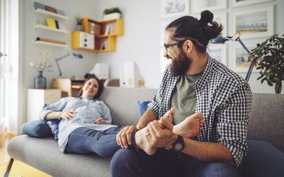 Man rubbing pregnant woman's feet