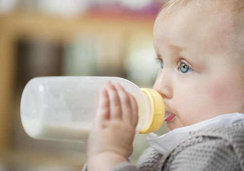 Close-up of a baby girl feeding milk